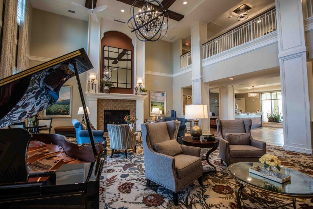 Interior shot of The Summit of Coralvilla's common area with high ceilings, grand piano, and comfortable seating.