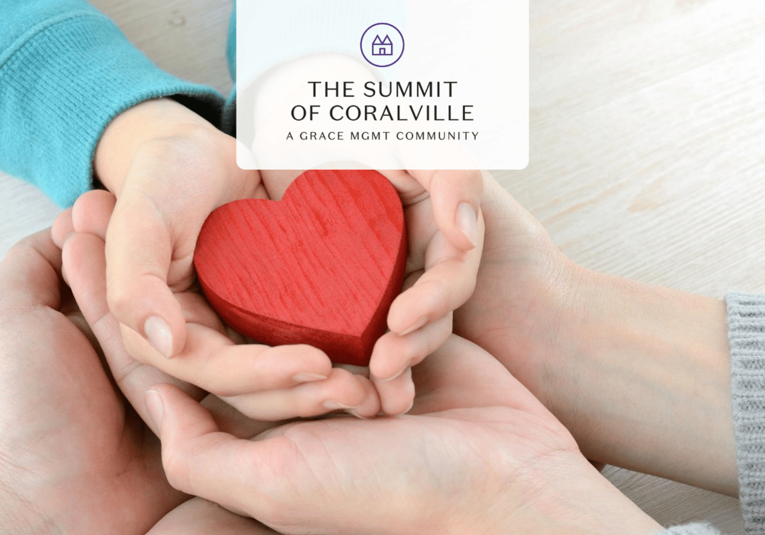 Hands cupping a red heart to symbolize care and community support (logo reads The Summit of Coralville).
